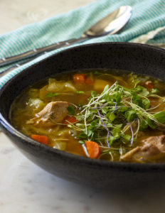 Make a bowl of comforting chicken soup with purple potatoes and carrots